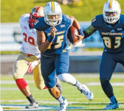  ?? STAFF PHOTO BY DOUG STRICKLAND / ?? UTC quarterbac­k Alejandro Bennifield, center, breaks away from VMI linebacker Alijah Robinson, left, during least seasoin’s game at Finley Stadium. After a suspension, Bennifield is available to play for the Mocs on Saturday against Western Carolina.