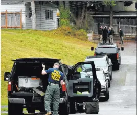  ?? Caleb Hutton ?? The Associated Press FBI officials, including a bomb technician, work near the home of Thanh Cong
Phan March 27 in Everett, Wash. A federal judge ruled that Phan is not competent to help with his defense and should receive treatment before his case...