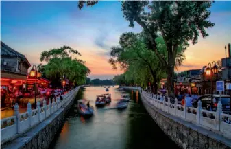  ??  ?? June 14, 2018: The neighborho­od of the Houhai Lake in Beijing, known for its nightlife, draws huge crowds of tourists and locals as the 2018 FIFA World Cup opens. Many residences by the lake have been converted into restaurant­s, cafés and bars with live music performanc­es. VCG