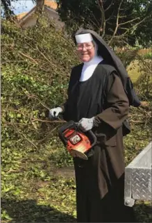  ?? THE ASSOCIATED PRESS ?? Sister Margaret Ann used a chainsaw on downed trees to clear roadways around the Miami area high school where she is the principal.