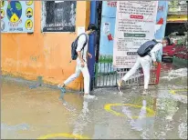  ?? RAJ K RAJ/HT PHOTOS ?? (From left) Students attend class at Sarvodaya Bal Vidyalaya on Rouse Avenue; Students wade through a waterlogge­d stretch outside a government school.