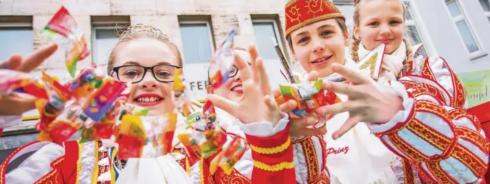  ??  ?? Prinzessin Gina und Prinz Kevin I. waren gestern die Stars beim Hamborner Kinderzug. Dass ihnen angesichts des nass-kalten Wetters auf dem Wagen kalt wurde, verhindert­en sie, indem sie reichlich Kamelle warfen und ihrem närrischen Volk zujubelten. Das...