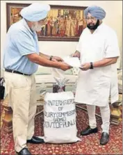  ??  ?? Justice Mehtab Singh Gill (retd) submitting the 8th interim report to chief minister Captain Amarinder Singh on Thursday. HT PHOTO