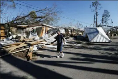  ?? GERALD HERBERT— THE ASSOCIATED PRESS ?? Clinton Moseley walks past debris in the aftermath of Hurricane Michael in Panama City, Fla., Saturday, Oct. 13, 2018.