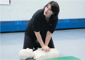  ??  ?? Instructor Kelly Dashney, who teaches life-saving techniques to everyday citizens, demonstrat­es rapid chest compressio­ns on a dummy.