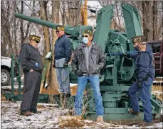  ??  ?? Taos VFW Post 3259 members wait by a World War II antiaircra­ft artillery cannon Saturday (Jan. 23) before its move to Not Forgotten Outreach’s Veteran’s Living Memorial Park.