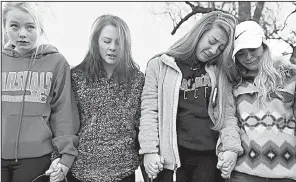  ?? AP/The Courier-Journal/MATT STONE ?? Students Brooklyn Boyce (left) and Katlyn Gamble join other Marshall County High School classmates at a prayer vigil Wednesday morning at Paducah Tighman High School in Paducah, Ky.