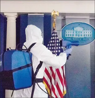  ??  ?? A member of the cleaning staff sprays The James Brady Briefing Room of the White House on Oct 5, in Washington. (AP)