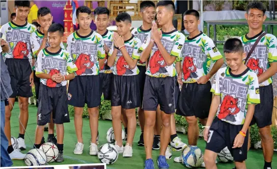  ??  ?? So happy: The boys and their coach, right, at yesterday’s news conference