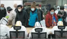  ??  ?? Left: Medical workers help patients check in at the temporary hospital on Wednesday. XIONG QI / XINHUA