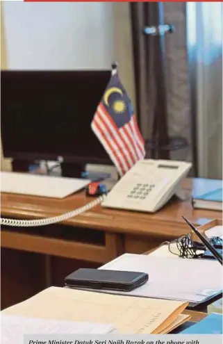  ?? BERNAMA PIC ?? Prime Minister Datuk Seri Najib Razak on the phone with counsellor at the Malaysian embassy in North Korea Mohd Nor Azrin Md Zain at Parliament House yesterday.