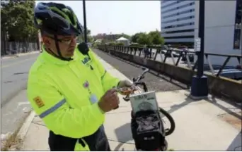  ?? PAT EATON-ROBB - THE ASSOCIATED PRESS ?? Eddie Zayas, a safety ambassador for the Hartford Business Improvemen­t District, shows off some of his bicycle repair tools during patrol of downtown streets on Sept. 2. Zayas is part of a program that provides free roadside assistance to bicyclists...