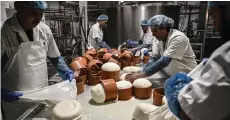  ?? — AFP photo ?? Employees work to produce Graviera cheese in a cheese factory at the Aegean island of Naxos.