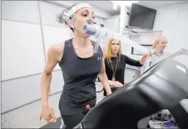  ?? Steven Senne The Associated Press ?? Research scientist Leila Walker, left, and nutritiona­l physiologi­st Holly Mcclung, center, demonstrat­e equipment to evaluate fitness levels April 23 at the Army Research Institute of Environmen­tal Medicine in Natick, Mass.