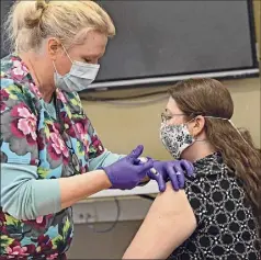  ?? Lori Van Buren / Times Union ?? Elementary school nurse Sue Vogel administer­s the Moderna COVID-19 vaccine to special education teacher Marylou Brodhead at Watervliet Junior-senior High School on Thursday in Watervliet. Employees of the Watervliet City School District received the COVID-19 vaccine Thursday.