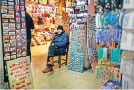  ??  ?? A vendor waits for customers in Istanbul’s Grand Bazaar, one of Istanbul’s main tourist attraction­s.
