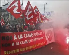  ??  ?? French rail workers demonstrat­e with a banner reading “No to social breakdown” in Paris on Tuesday. French unions plan strikes two days every week through June to protest government plans to eliminate some rail worker benefits — part of broader...