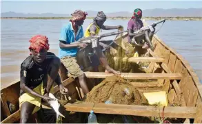  ??  ?? LOWARENGAK, Kenya: Armed fishermen from Kenya’s Turkana county return from a fishing expedition aboard a boat near Lowarengak, on the western shores of Lake Turkana, northern Kenya.