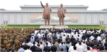  ?? (KCNA/Reuters) ?? PEOPLE AND SOLDIERS gather to offer flowers to the statues of state founder Kim Il Sung and former leader Kim Jong Il on the Day of Songun at Mansu hill, Pyongyang, in this undated photo released yesterday.