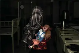  ?? EBRAHIM NOROOZI — THE ASSOCIATED PRESS ?? Nazia 30, who has lost four children due to severe malnutriti­on, holds her malnourish­ed baby in a hospital in Parwan province north of Kabul, Afghanista­n.