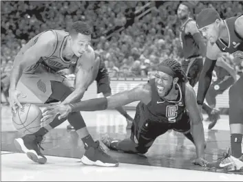  ?? Steve Dykes Associated Press ?? CJ McCOLLUM, who scored 23 points for the Trail Blazers, grabs a loose ball in front of backup Clippers center Montrezl Harrell. Harrell finished with 19 points, six rebounds and three blocked shots.