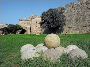  ??  ?? Cannon balls are neatly piled outside the Rhodes city wall.