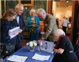  ?? ?? Ann Darracott signing a copy of her book at last week’s launch event.