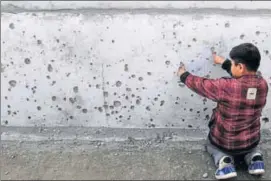  ?? NITIN KANOTRA/HT ?? A boy shows the splinter marks on a wall left by Pakistanfi­red mortar shells in Jammu and Kashmir’s Arnia district on Thursday.