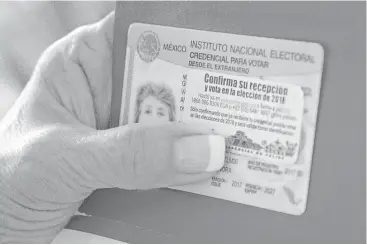  ?? Houston Chronicle ?? Amanda Logan muestra su tarjeta de identifica­ción para votar desde el extranjero en las elecciones de México, el 1 de febrero de 2018 en Aldine, al norte de Houston. Dijo que ha intentado registrar la tarjeta y que el sistema no se lo ha permitido para...