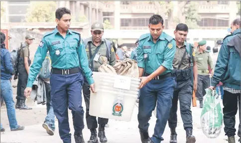  ??  ?? Bangladesh­i security personnel carry polling materials at a distributi­ng centre in Dhaka. — AFP photos
