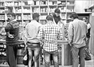  ?? — Bloomberg photo by Udit Kulshresth­a ?? Customers wait at a counter at a Patanjali Ayurved Ltd. store in New Delhi.