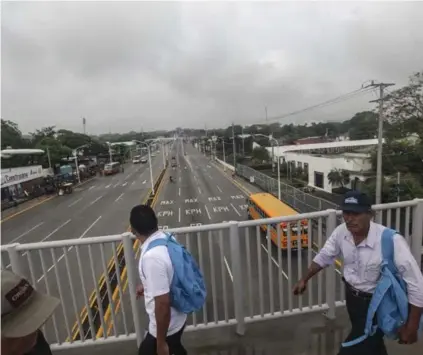  ?? AP ?? Hombres cruzaban una carretera con poca circulació­n debido a la huelga general convocada por la oposición al gobernante Daniel Ortega, en Managua, Nicaragua, este jueves.
