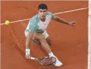  ?? AP PHOTO/CHRISTOPHE ENA ?? Spain's Carlos Alcaraz plays a shot against Italy's Flavio Cobolli during their first round match of the French Open tennis tournament Monday at the Roland Garros stadium in Paris.