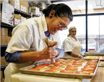  ?? LISA POWELL / STAFF ?? Laura Enzbrenner, the founder of Laura’s Cookies, which are sold at Dorothy Lane Market, decorates cookies for the Thanksgivi­ng holiday. Enzbrenner said she would make 10,000 cookies this year during the week of Thanksgivi­ng.