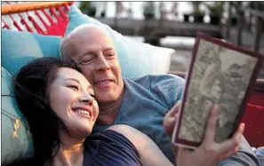  ?? PROVIDED TO CHINA DAILY ?? US film star Bruce Willis (right) reads a book with Chinese actress Xu Qing in a scene from the movie Looper. Hollywood has paid increasing attention to the Chinese market, which is expected to be the world’s biggest box office in less than 10 years.
