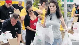  ?? JOE CAVARETTA/STAFF PHOTOGRAPH­ER ?? Workers and volunteers give away some of one thousand Thanksgivi­ng turkeys handed out to the needy, Monday, at Cheetah Gentleman's Club in Hallandale Beach. The club charity gave away a total of 3,000 turkeys at three locations, Hallandale Beach,...