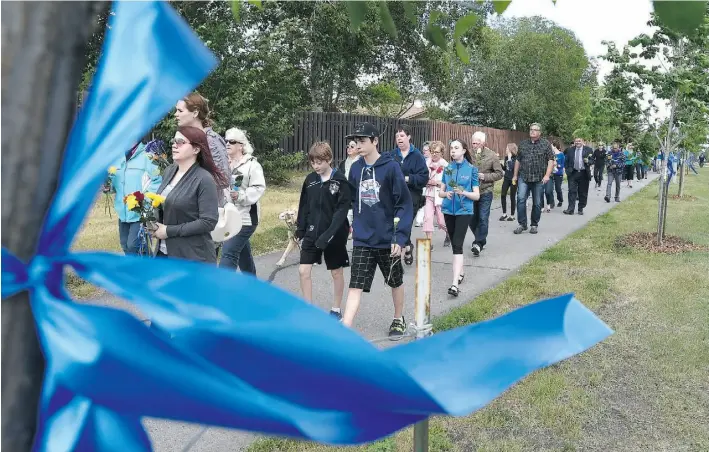  ?? ED KAISER/EDMONTON JOURNAL ?? About 100 people take part in a prayer walk Friday in the Ormsby Place neighbourh­ood where Const. Daniel Woodall was shot and killed Monday executing an arrest warrant.