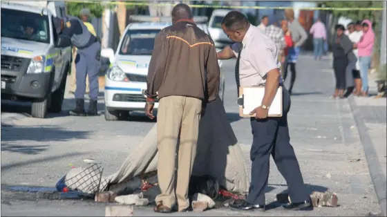  ?? Picture: SANDISO PHALISO/WCN ?? VICTIM: Police cover the burnt corpse of an Angolan man who was necklaced in Philippi yesterday. Due to the corpse being left in the street, it was partly eaten by dogs.