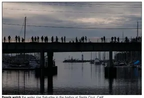  ?? (AP/Nic Coury) ?? People watch the water rise Saturday in the harbor at Santa Cruz, Calif.