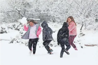  ?? PHOTOS BY ROB SCHUMACHER/THE REPUBLIC ?? Children have a snowball fight on a fairway at the Apache golf course at Desert Mountain in Scottsdale as a winter storm on Tuesday brought five inches of snow to the north Scottsdale area.