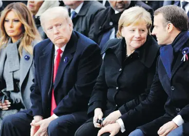  ?? FRANCOIS MORI / AFP / GETTY IMAGES ?? French President Emmanuel Macron, right, beside German Chancellor Angela Merkel as they sit next to President Donald Trump and first lady Melania Trump in Paris on Sunday.