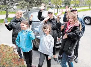  ?? PHOTOS BY JOHN RENNISON THE HAMILTON SPECTATOR ?? The Perks clan waves to family matriarch Florence Perks, below, who was in her second-floor room at Heritage Green Nursing Home on Mother’s Day. They also talked to her by cellphone.