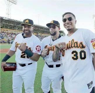  ?? F.E. ?? Wilin Rosario (izq.), Juan Carlos Pérez y Johan Camargo muestran sus anillos de campeones entregados por las Águilas previo al partido de ayer ante el Licey.