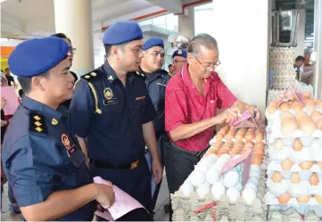  ??  ?? File photo showing KPDNKK enforcemen­t officers checking the prices of eggs at Sibu Central Market.