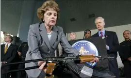  ?? DAVID MCNEW — GETTY IMAGES ?? California Gov. Gray Davis watches as Sen. Dianne Feinstein picks up an AK-47assault rifle during a 2003news conference to urge Congress to extend the assault weapons ban.