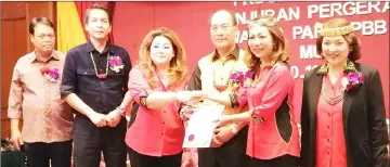  ??  ?? Gerawat (third right) witnesses his wife Datin Esther Mujan Balan (second right) presenting a certificat­e to a programme participan­t as (from right) Catherine, Dennis and councillor Simpson Njok look on.