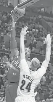  ?? Steve Dykes / Associated Press ?? Rockets center Dwight Howard, left, shoots over the Blazers’ Mason Plumlee during Howard’s 28-point game Wednesday night.