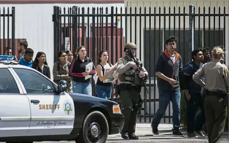  ??  ?? Fleeing to safety: Highland High School students being escorted from campus by police after the shooting in Palmdale, California.