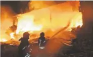  ?? Provided by Syrian Civil Defense White Helmets ?? Syrian White Helmet civil defense workers extinguish a fire at the scene of an explosion that hit a five-story building, in the village of Sarmada, near the Turkish border, north Syria, on Sunday.