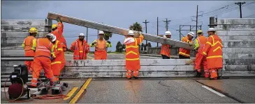  ?? NICK WAGNER / AMERICAN-STATESMAN ?? Texas Department of Transporta­tion crews build a surge wall in Aransas Pass as Hurricane Harvey nears Aug. 25. Despite its unofficial name, the rainy day fund has never been used to pay for hurricane relief.